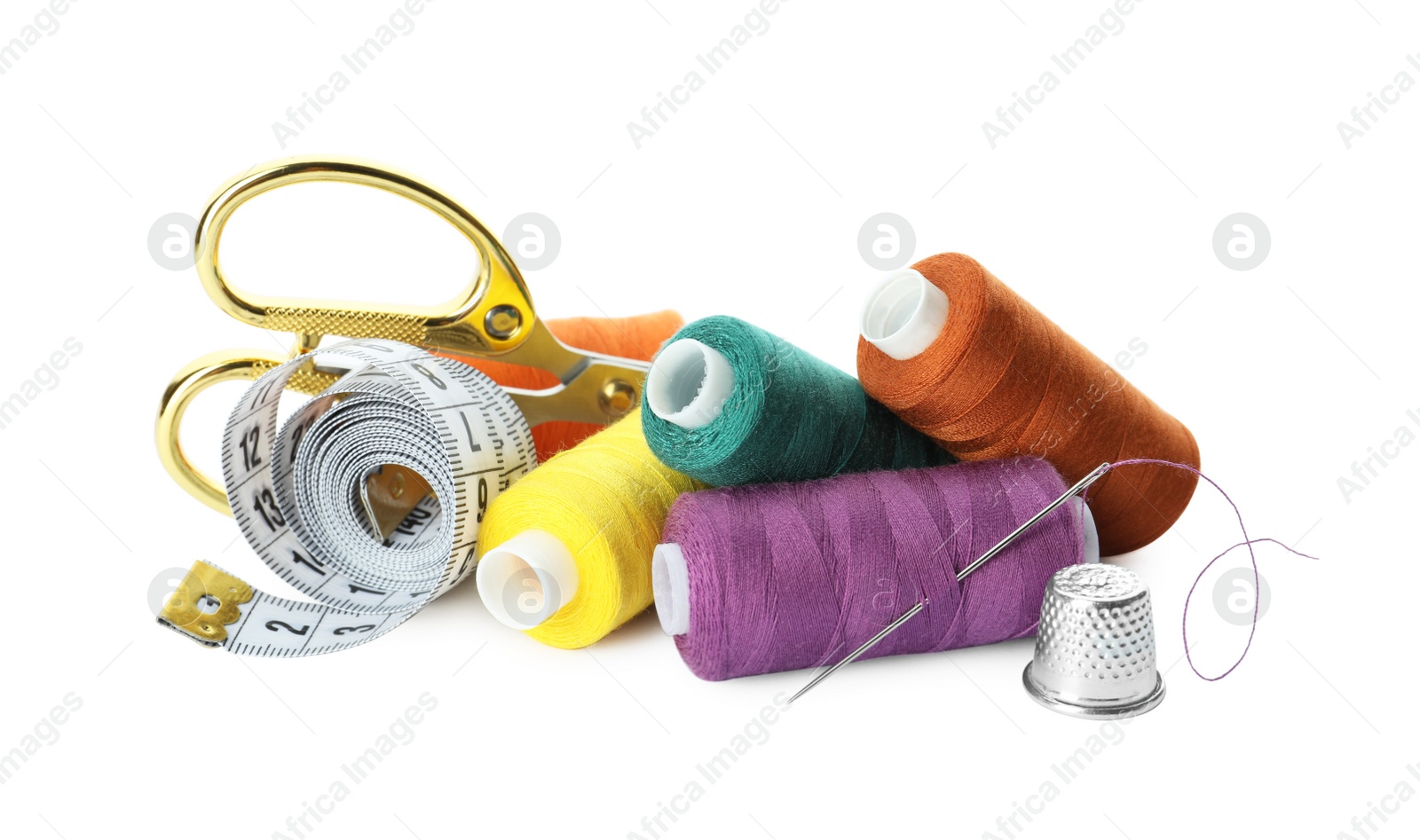 Photo of Spools of threads and sewing tools on white background