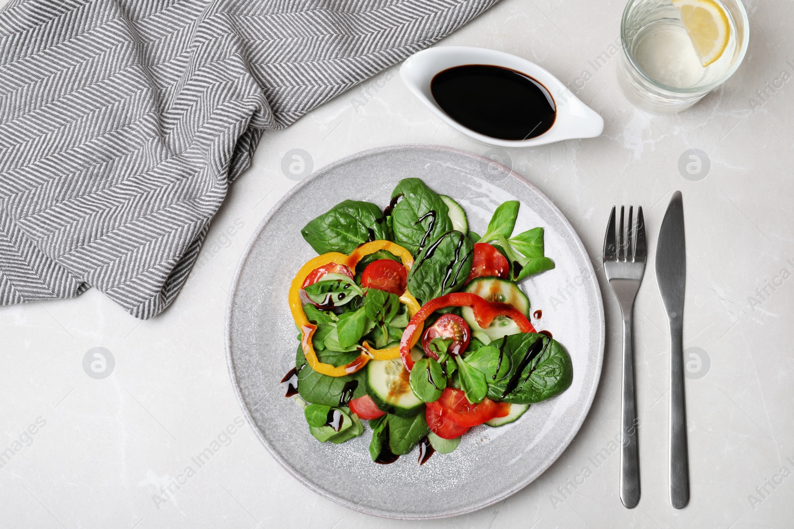 Photo of Fresh vegetable salad and balsamic vinegar served on table, top view