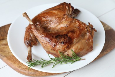 Tasty cooked rabbit meat with rosemary on white table, closeup