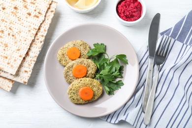 Flat lay composition with plate of traditional Passover (Pesach) gefilte fish on wooden background