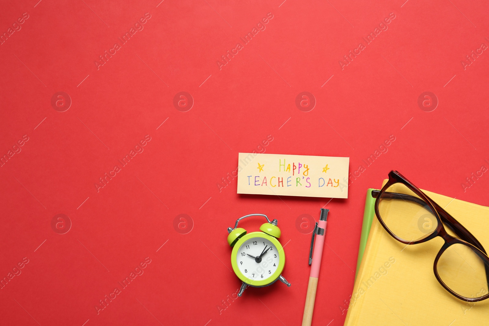 Photo of Flat lay composition of card with inscription HAPPY TEACHER'S DAY and stationery on red background, space for text