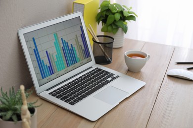 Photo of Stylish workplace with laptop on wooden desk. Interior design