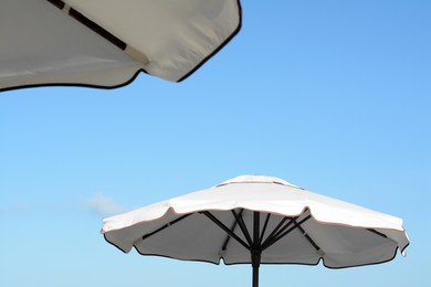 Photo of Beautiful white beach umbrellas against blue sky