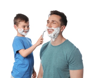 Photo of Little son shaving his dad on white background