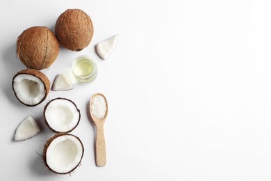 Jar of natural organic oil and coconuts on white background, top view