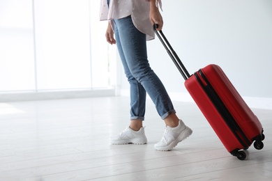 Photo of Woman with red travel suitcase in airport