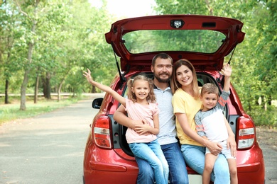 Happy family with children and car, outdoors. Taking road trip together