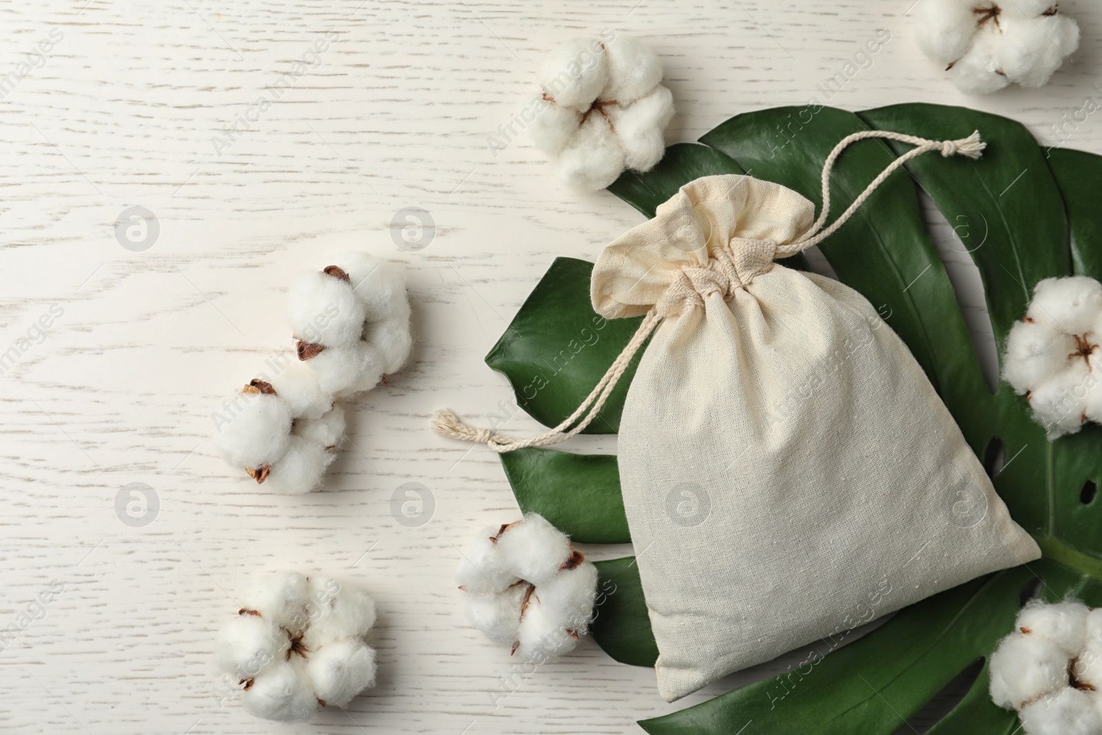 Photo of Full cotton eco bag on white wooden table, flat lay