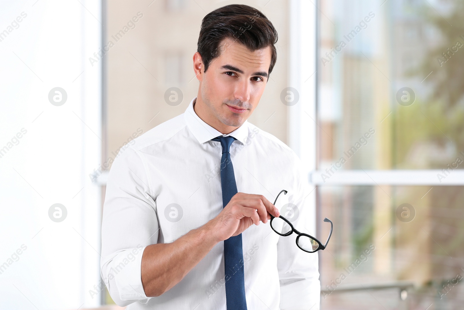Photo of Handsome young man in stylish clothes with glasses indoors