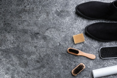 Stylish footwear with shoe care accessories on grey stone table, flat lay. Space for text