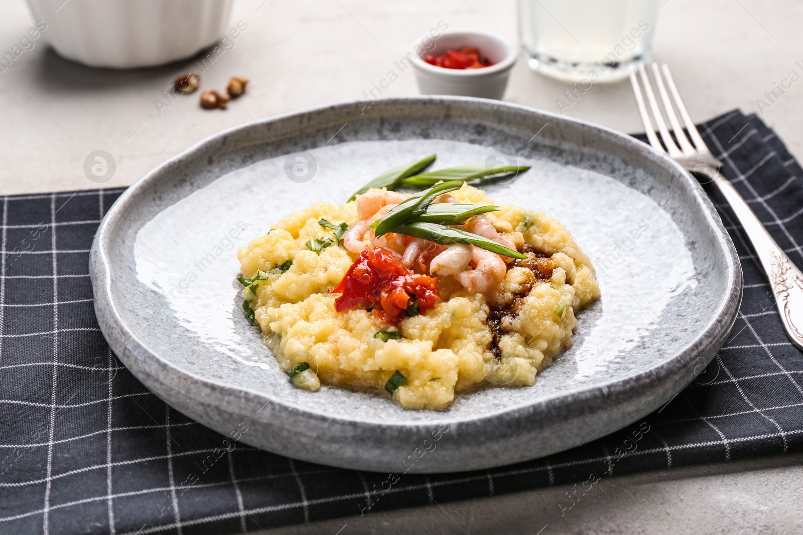 Photo of Plate with tasty shrimps and grits on table