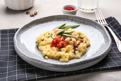 Photo of Plate with tasty shrimps and grits on table