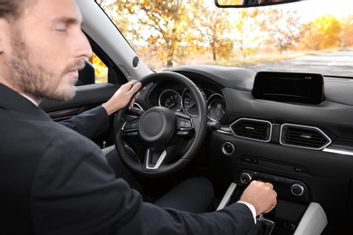 Photo of Young man in driver's seat of modern car