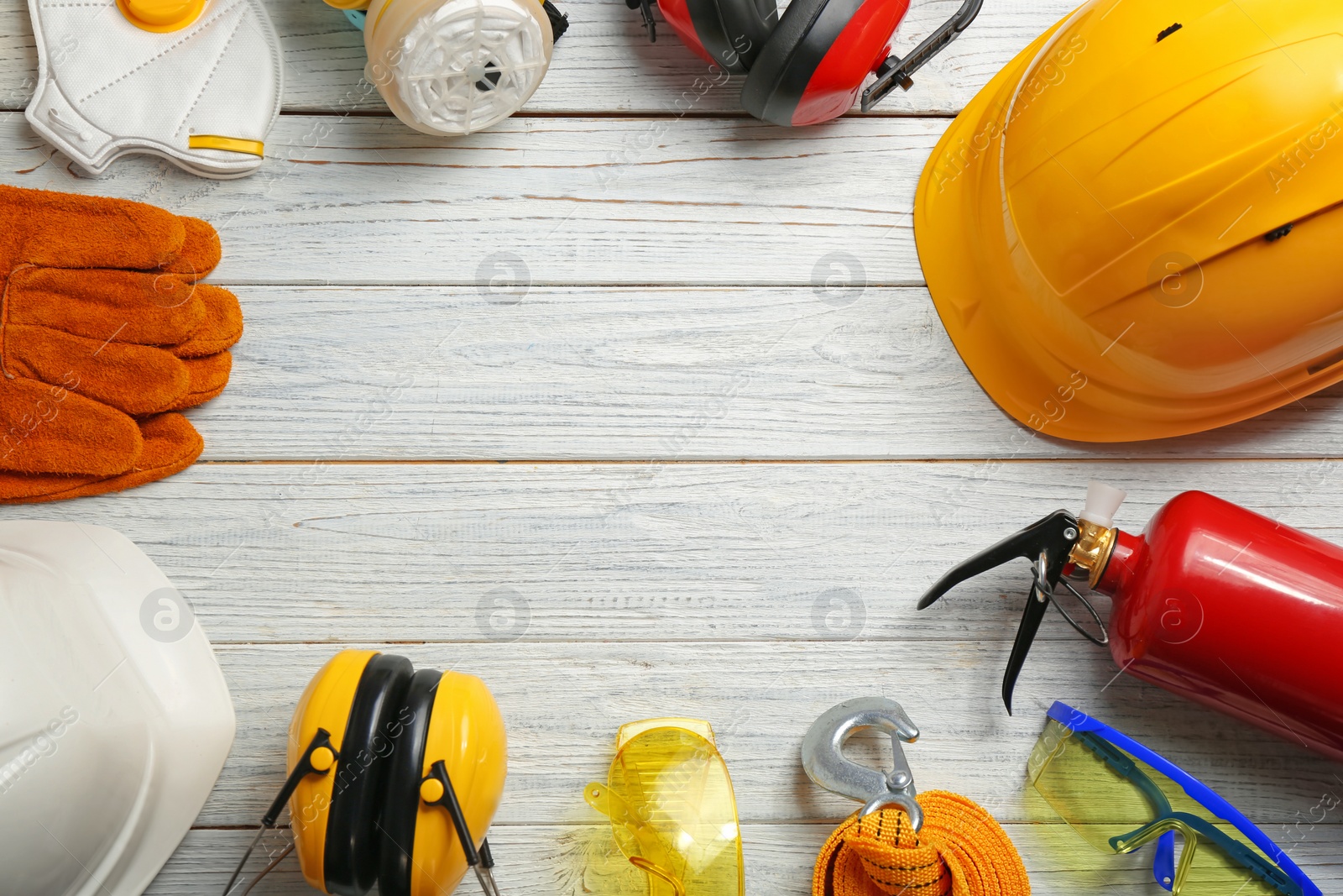 Photo of Flat lay composition with safety equipment and space for text on wooden background