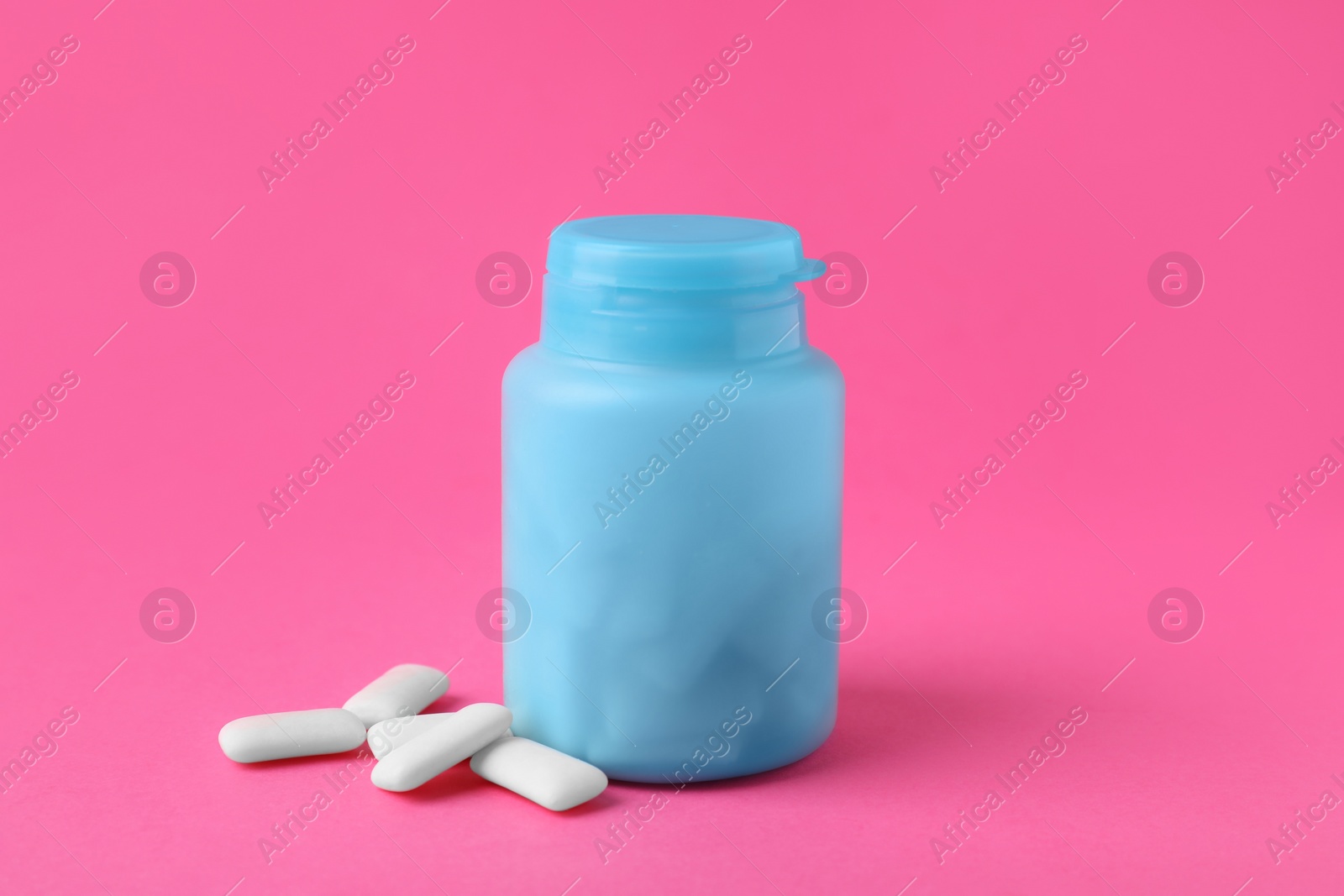 Photo of Jar with chewing gums on pink background