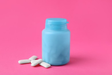 Jar with chewing gums on pink background