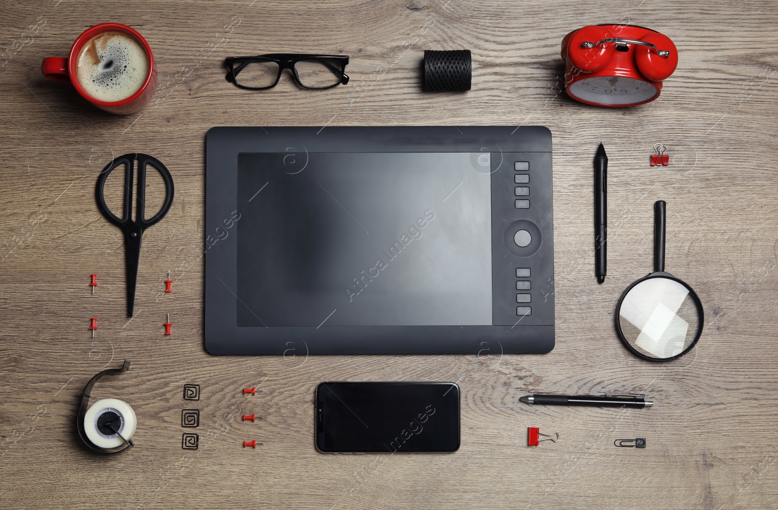 Photo of Flat lay composition with graphics tablet, smartphone and stationery on wooden table. Designer's workplace