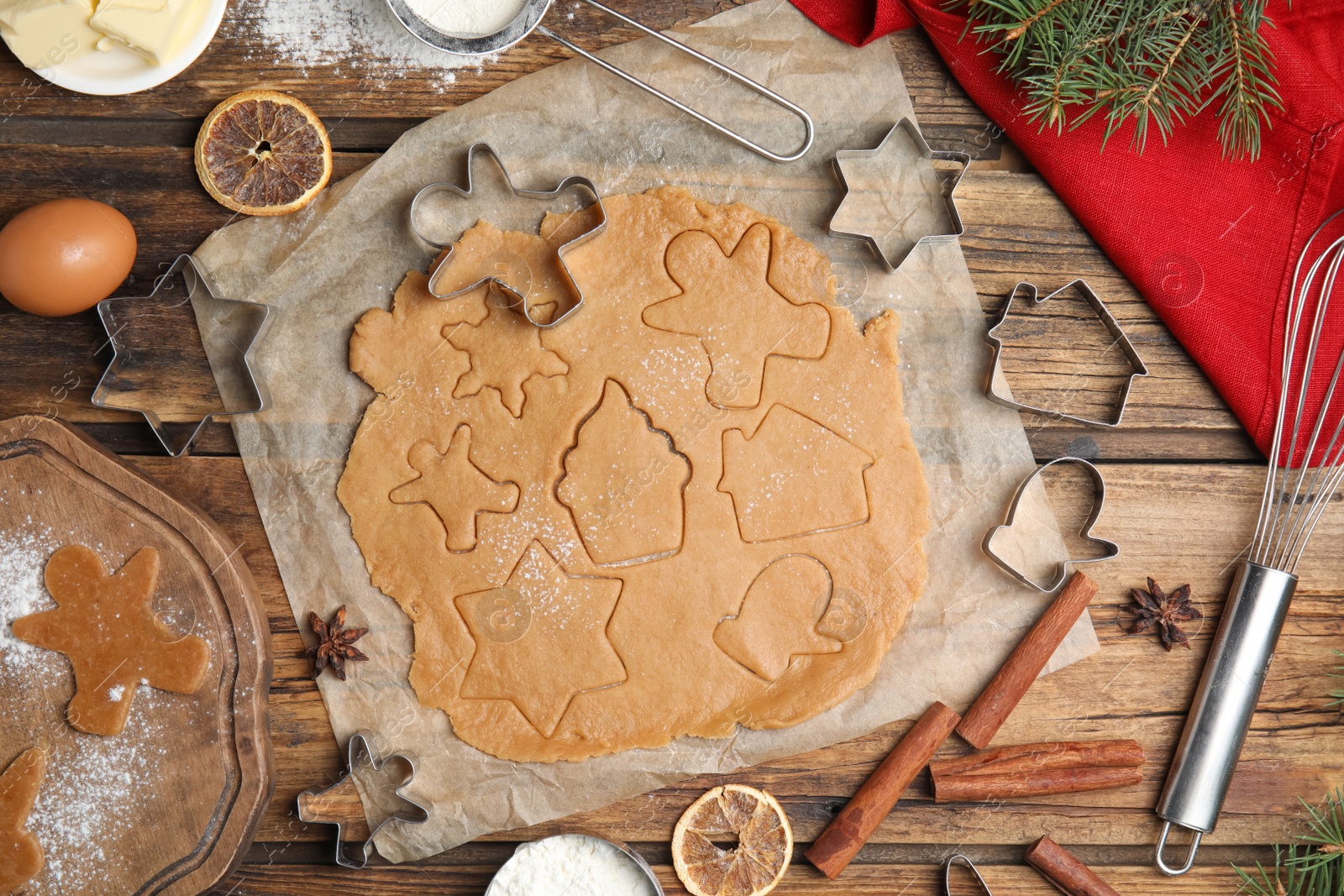 Photo of Making homemade Christmas cookies. Flat lay composition with dough and cutters on wooden background