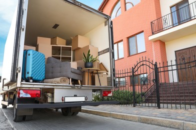 Photo of Van full of moving boxes and furniture near house