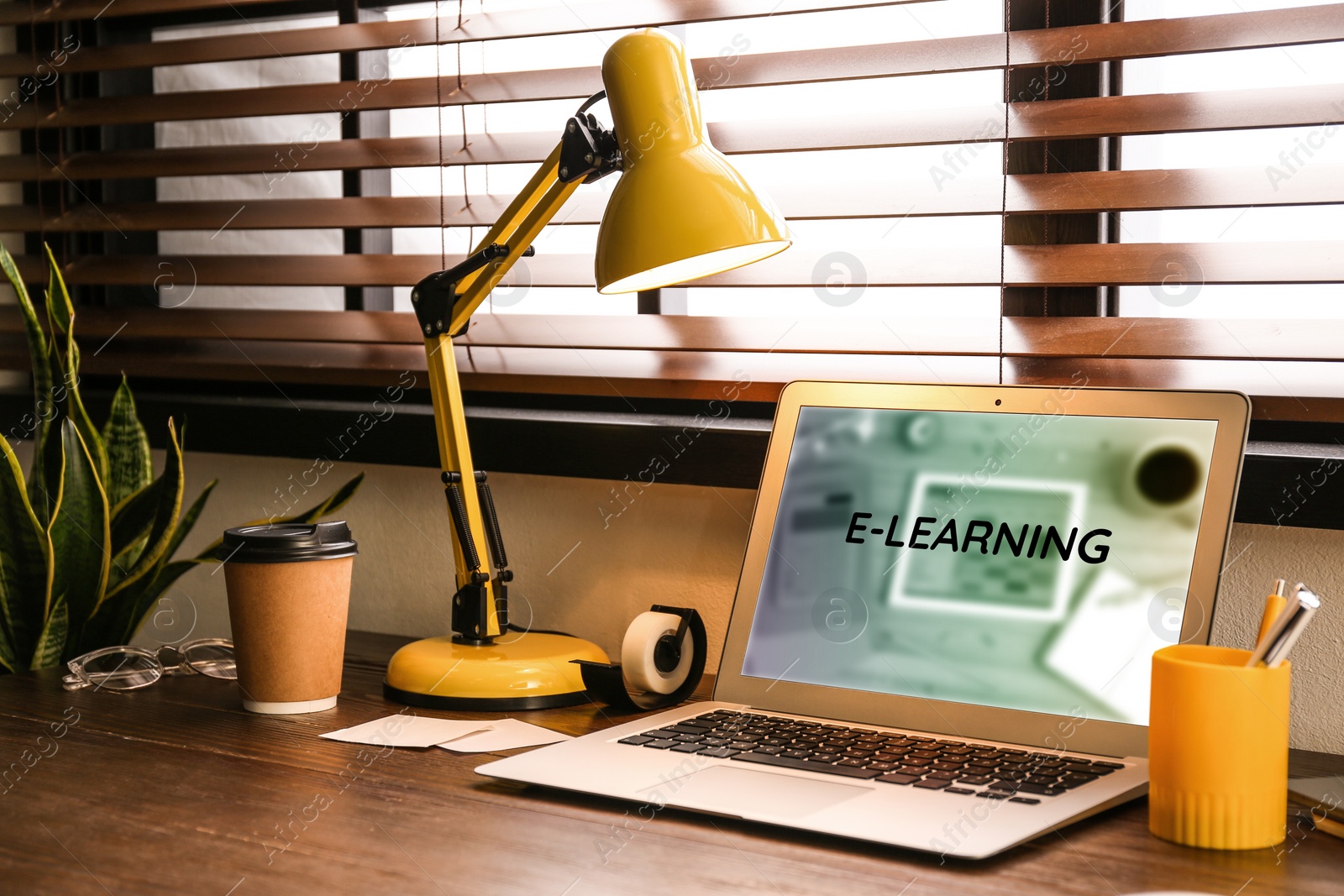 Image of Modern laptop on wooden desk indoors. Online learning