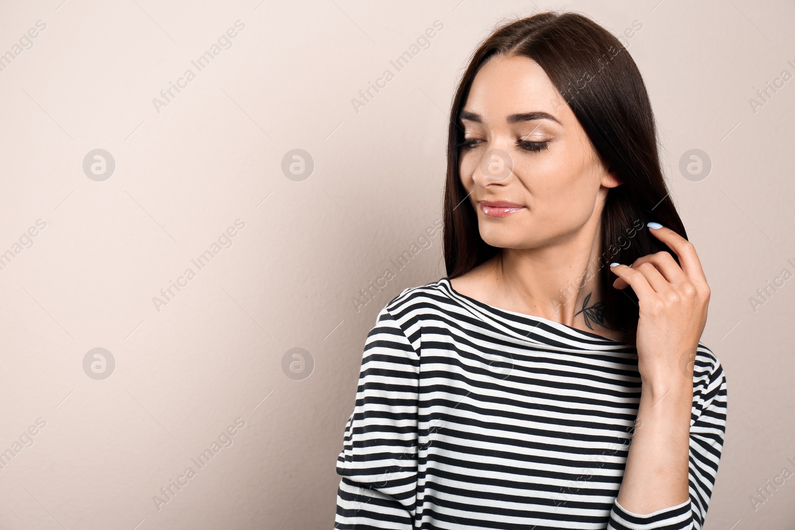 Photo of Portrait of pretty young woman with gorgeous chestnut hair on light background, space for text