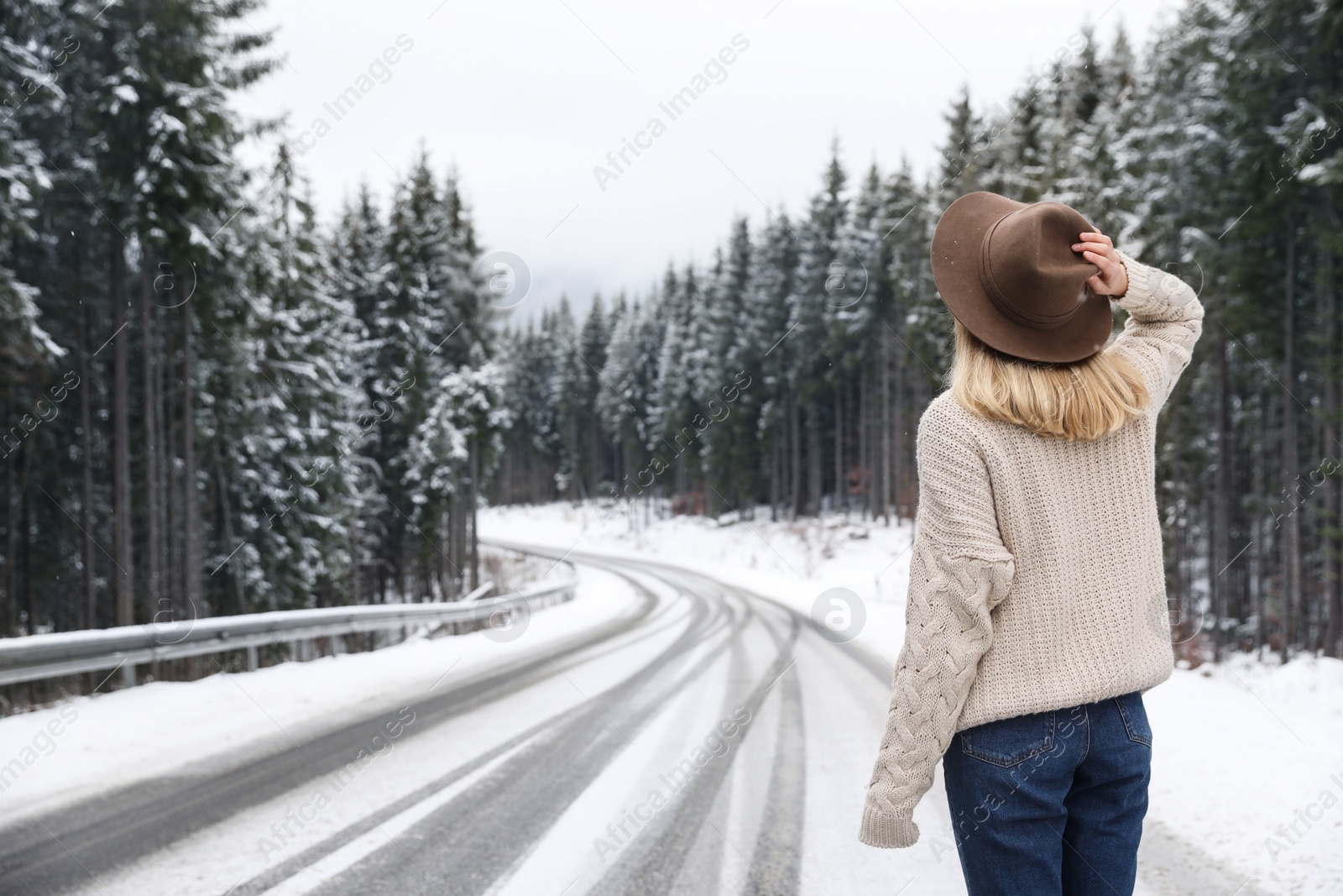 Photo of Young woman walking near snowy forest. Winter vacation