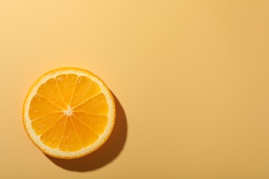 Slice of juicy orange on beige background, top view. Space for text
