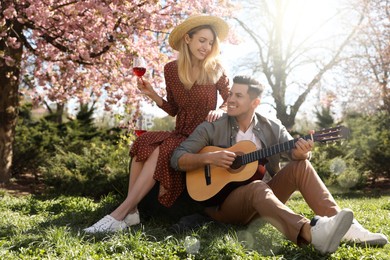 Photo of Lovely couple having picnic in park on sunny spring day