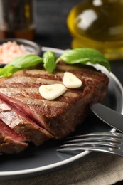 Photo of Delicious grilled beef steak served with spices on table, closeup