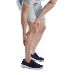 Young man suffering from leg pain on white background, closeup