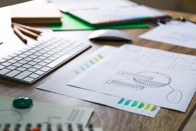 Sheets of paper with sketches on wooden table. Designer's workplace