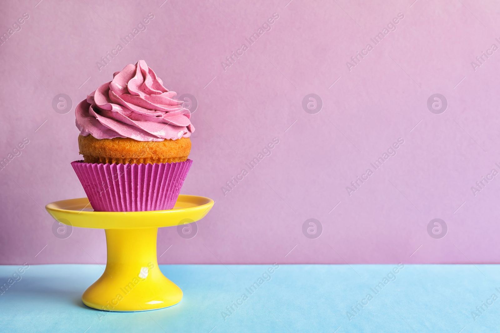 Photo of Delicious birthday cupcake with cream on color background