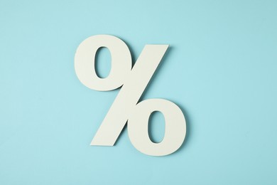 Photo of White percent sign on light blue background, top view