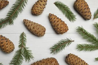 Photo of Flat lay composition with pinecones on white wooden background