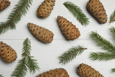 Flat lay composition with pinecones on white wooden background