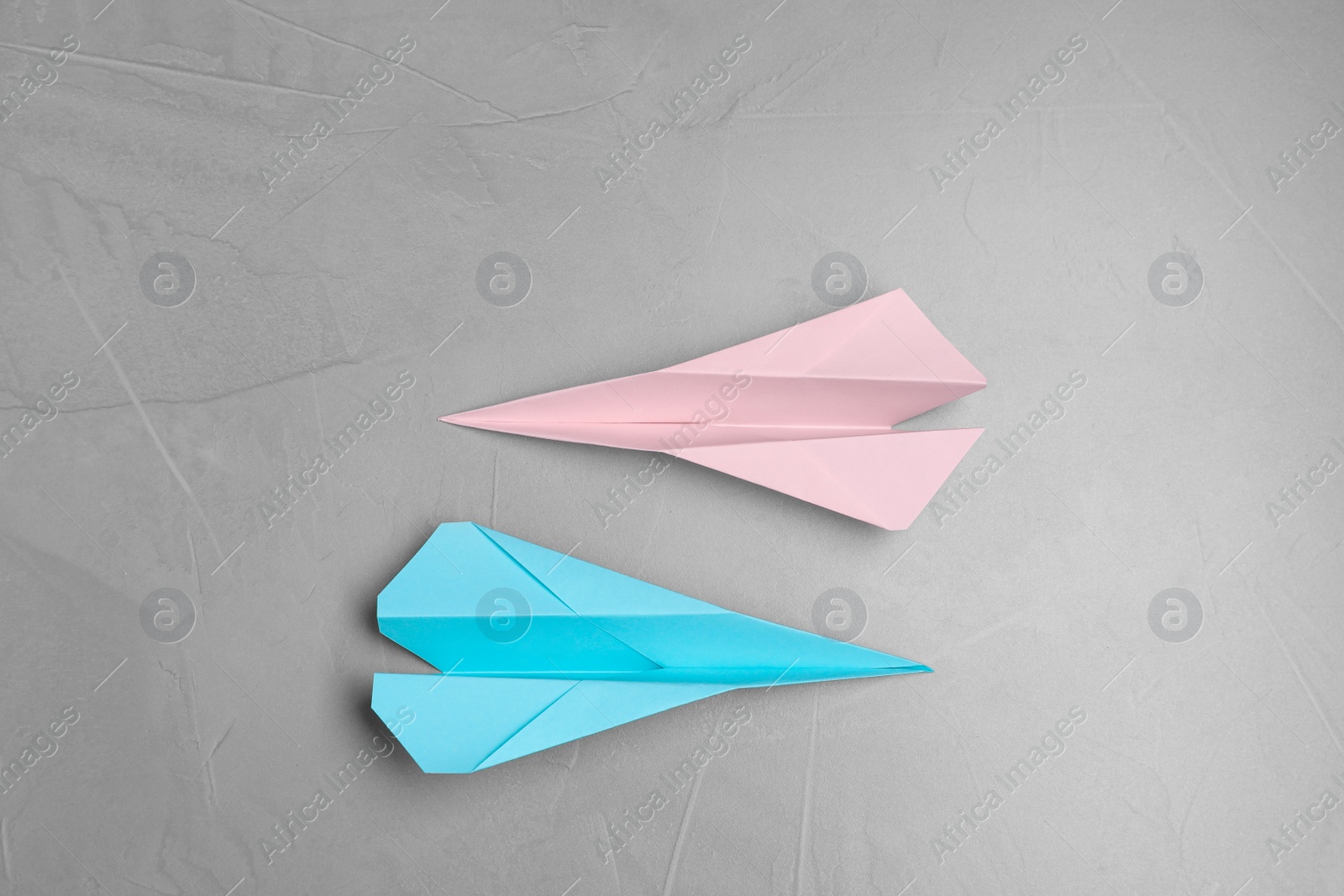 Photo of Handmade paper planes on light grey table, flat lay