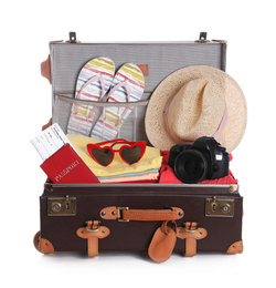 Photo of Open vintage suitcase with clothes packed for summer vacation isolated on white