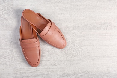 Photo of Pair of female shoes on wooden background, top view