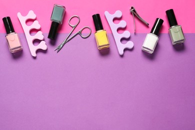 Photo of Nail polishes, clippers, scissors and toe separators on color background, flat lay. Space for text