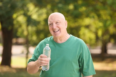 Photo of Elderly man with bottle of water outdoors on sunny day