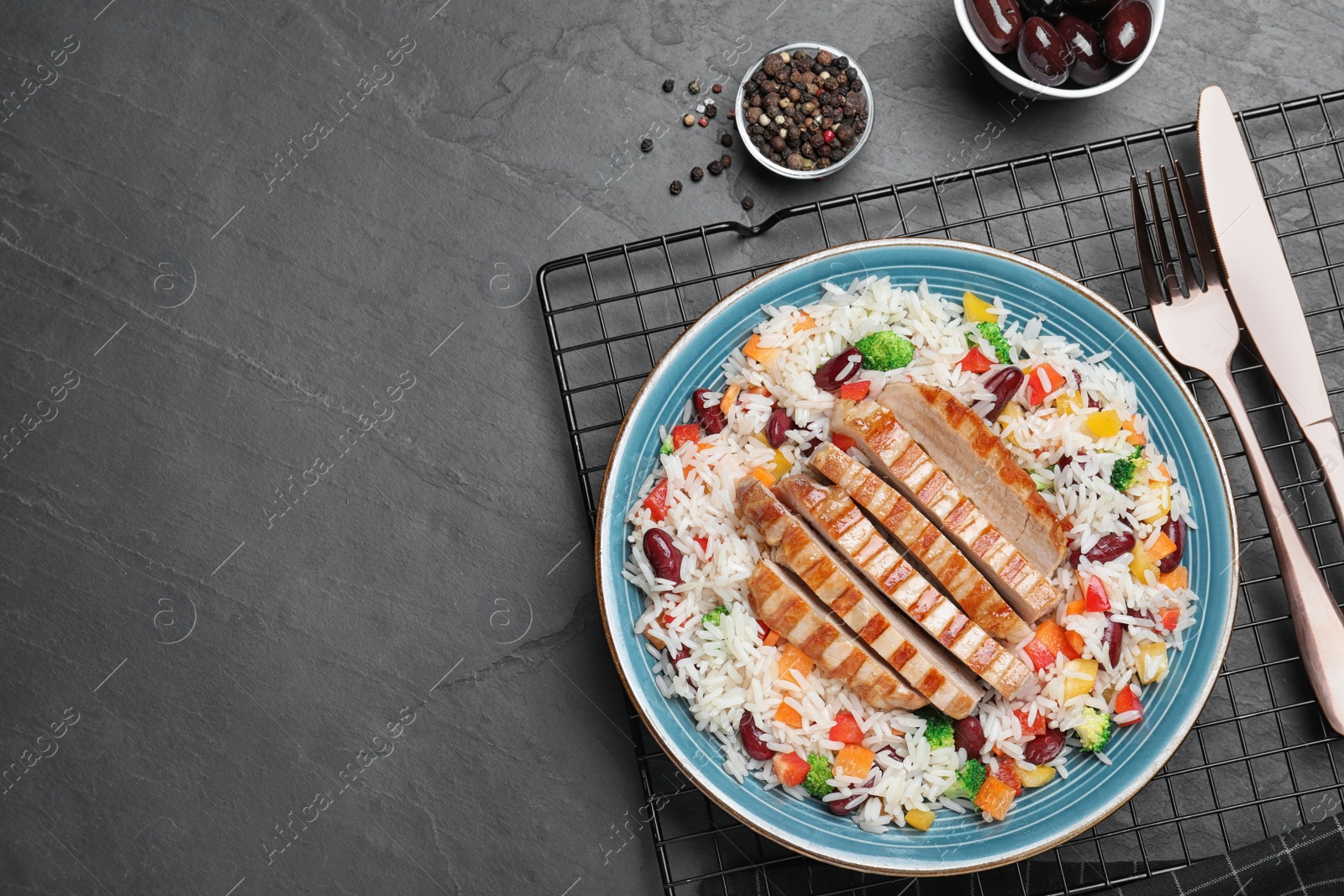 Photo of Tasty rice with beans and meat served on black table, flat lay. Space for text