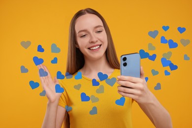 Long distance love. Woman video chatting with sweetheart via smartphone on golden background. Hearts flying out of device