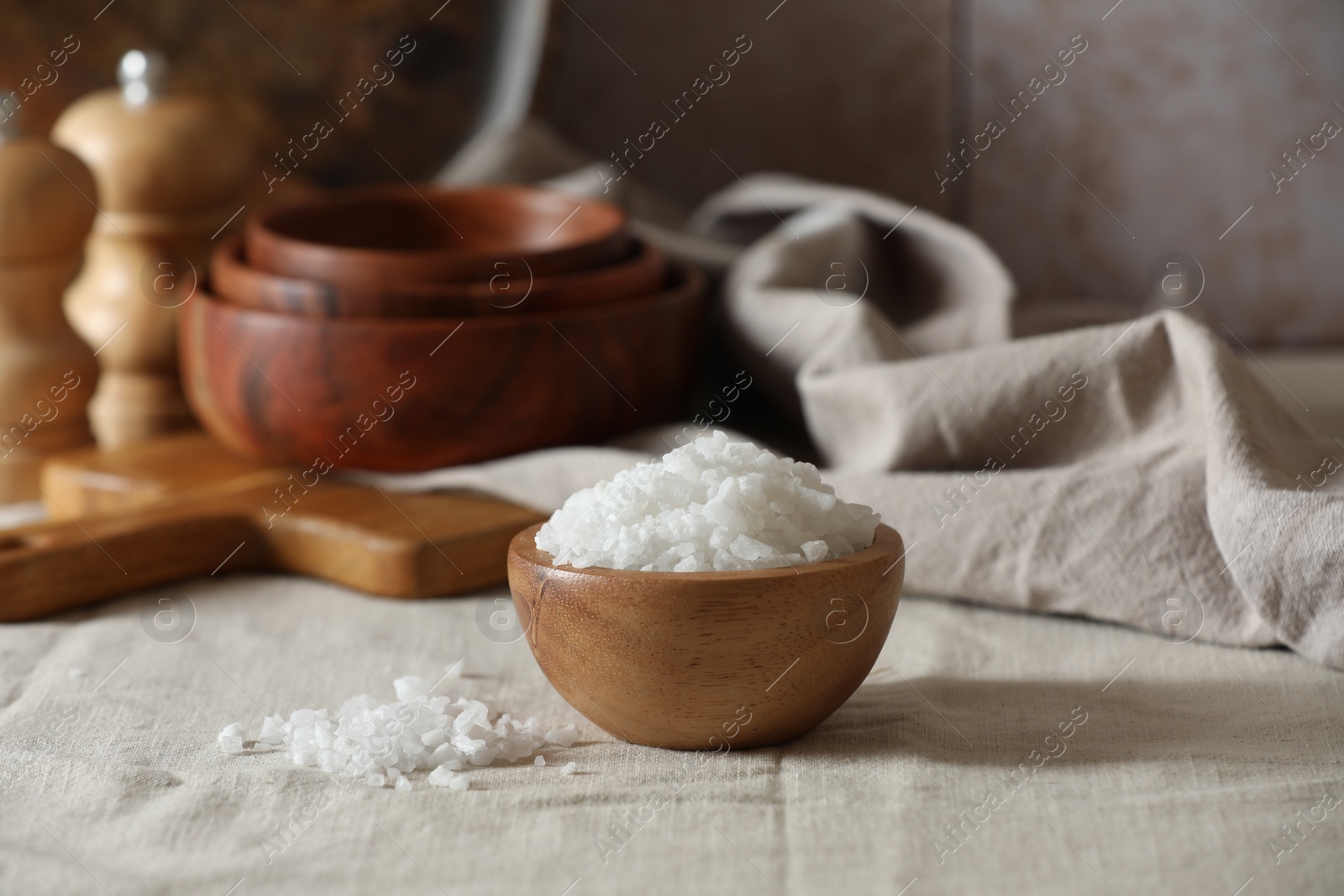 Photo of Organic salt in wooden bowl on table