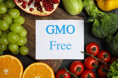 Tasty fresh GMO free products and paper card on table, top view