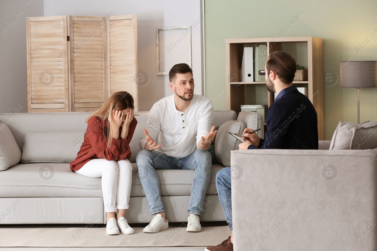 Photo of Family psychologist working with young couple in office