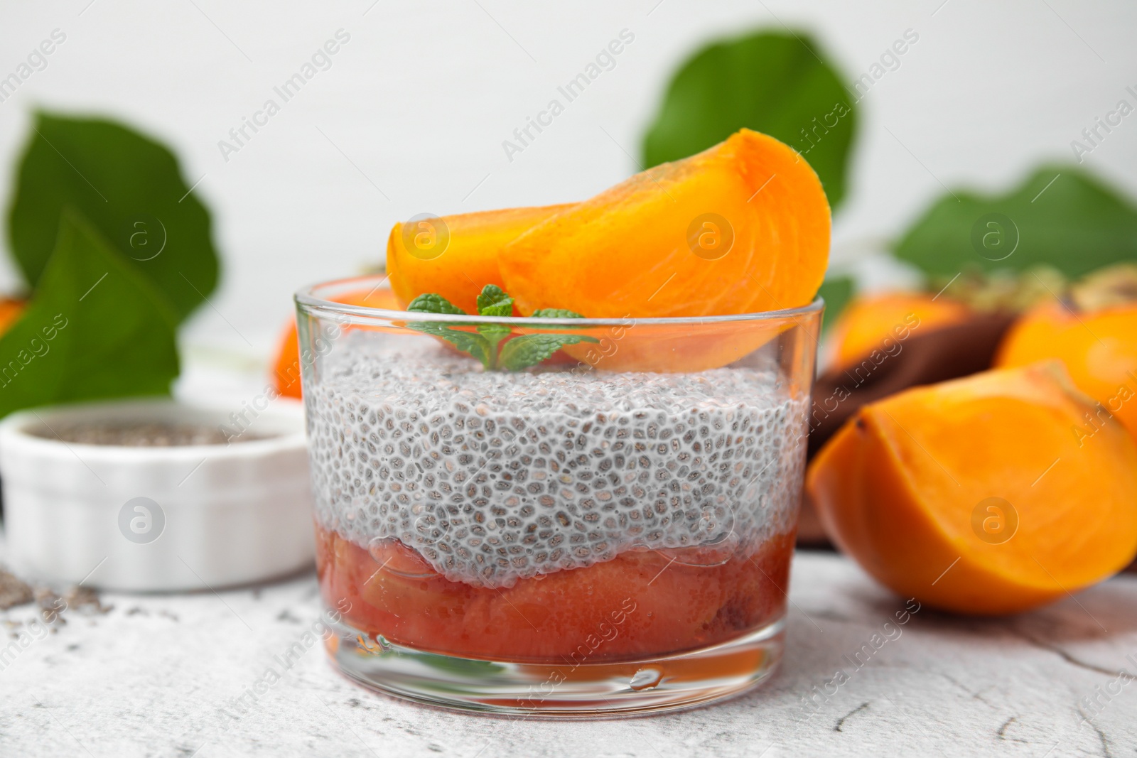 Photo of Delicious dessert with persimmon and chia seeds on table