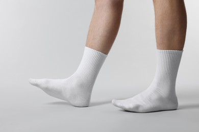 Photo of Man in stylish white socks on light grey background, closeup