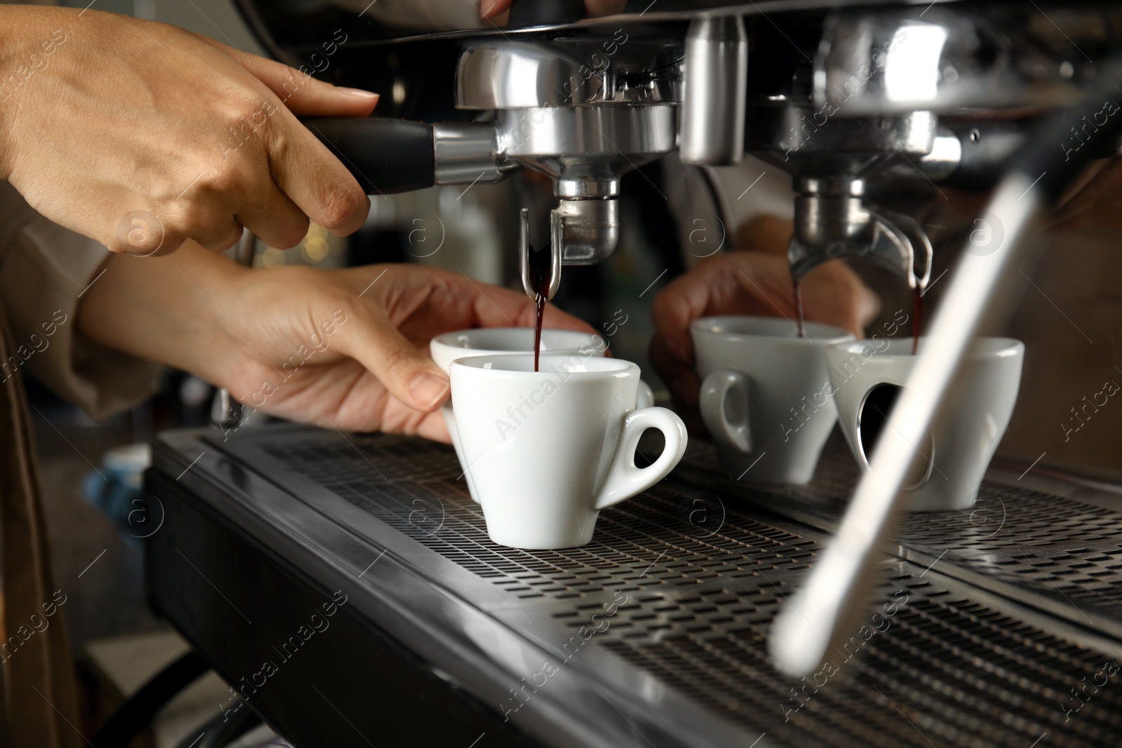 Photo of Barista making espresso using professional coffee machine, closeup