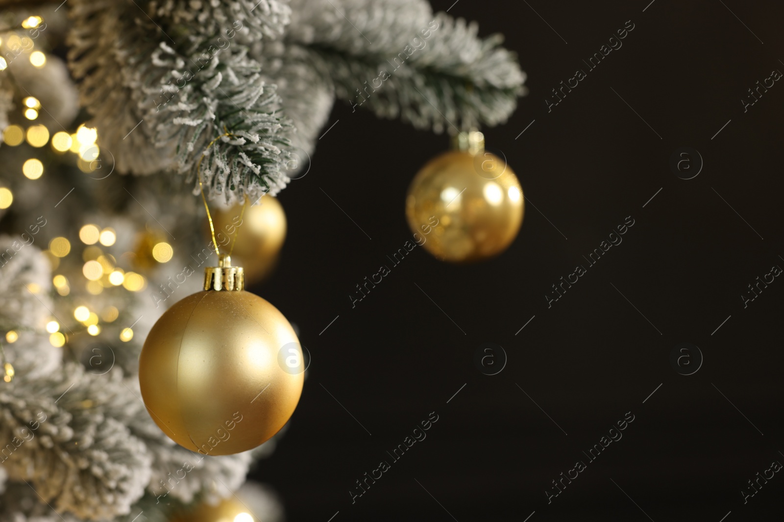 Photo of Beautiful decorated Christmas tree with baubles and lights on black background, closeup. Space for text
