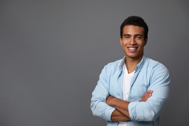 Photo of Handsome young African-American man on grey background. Space for text